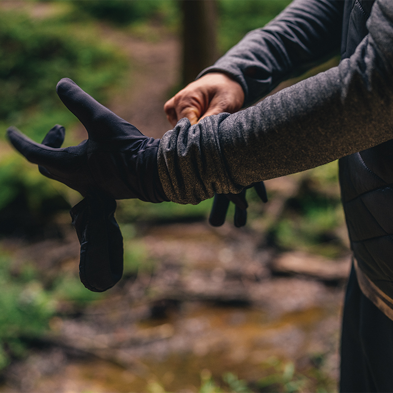 A person pulling a glove onto their hand.